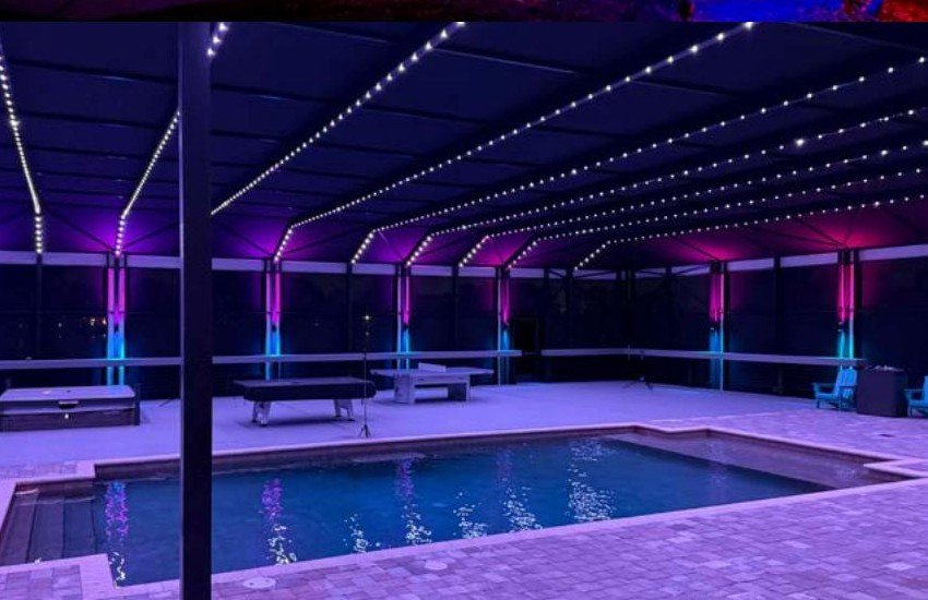 Screened pool enclosure with Brighter Nights by TrueSpec sconce lighting in blue and magenta